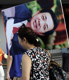 A Chinese woman carries a protrait of Bo Xilai, until recently a rising political star with little tolerance for critics. (AFP)