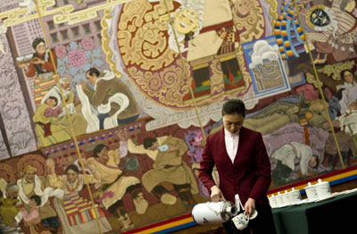 A hostess fills tea cups for delegates inside the Tibet room at the Great Hall of the People before the Tibetan delegation meets as part of the National People's Congress in Beijing Wednesday. (AP/Andy Wong)