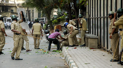 A group of lawyers attacked journalists outside a courthouse in Bangalore today. Here, a reporter helps an injured police officer. (AP)