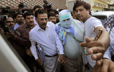 Plainclothes police escort Syed Mohammed Kazmi, an alleged suspect in last month's bombing of an Israeli diplomatic vehicle, from a local court, in New Delhi Wednesday. (AP/Manish Swarup)