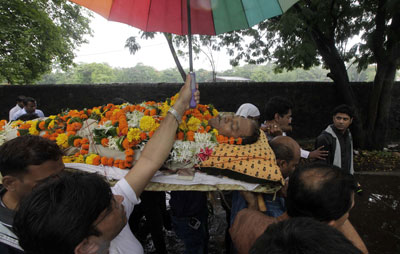 The confessed mastermind of the murder of crime reporter Jyotirmoy Dey, whose June 2011 funeral is shown here, remains free. (AP/Rajanish Kakade)