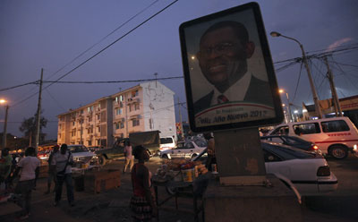 People walk near a portrait of Equatorial Guinea's President Teodoro Obiang along a street in Malabo. (Reuters/Luc Gnago)