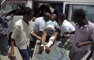 Medical personnel help a man wounded in the explosion in Mogadishu today. (AP/Farah Abdi Warsameh)