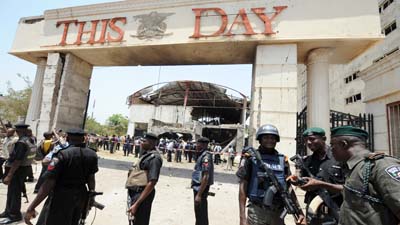 Police officers stand in front of ThisDay newspaper in Abuja, which was bombed earlier today. (AFP/Pius Utomi Ekpei)
