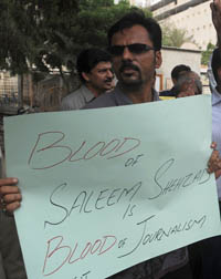 A Pakistani journalist holds a sign at a protest against Shahzad's murder in Karachi last year. (AFP/Rizwan Tabassum)