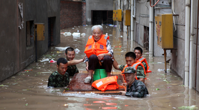 Rescuers evacuate a Chinese woman from her home. (AFP)