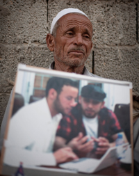Abdala Fassouk, the father of Abdelqadir Fassouk, holds a picture of the two cameramen. (AP/Manu Brabo)