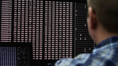 An analyst looks at malware code in a lab. (Reuters/Jim Urquhart)