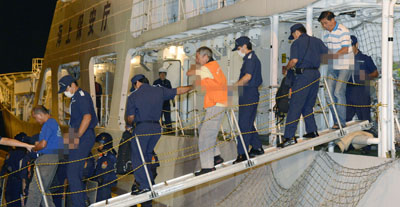 Chinese activists are escorted as they disembark from a Japan Coast Guard patrol ship. (Reuters/Kyodo)