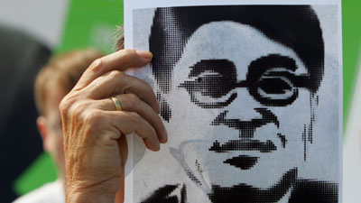 A protester holds a poster depicting jailed journalist Shi Tao. (AP/Miguel Villagran)
