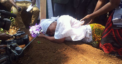 The wife of journalist Daudi Mwangosi weeps at his grave. Mwangosi was killed in a scuffle with police on Sunday. (Gustav Chahe)