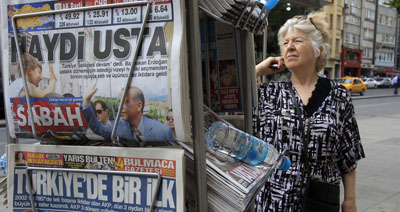 A passer-by looks at Turkish newspapers at a kiosk in Istanbul. (AP/Thanassis Stavrakis)