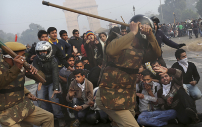 Police beat protesters near India Gate, New Delhi. (AP/Kevin Frayer)