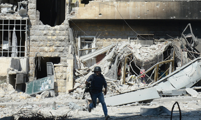 Um jornalista se esquiva tiros na cidade síria de Aleppo (AFP/Tauseef Mustafa)
