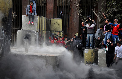 Egyptian protesters tear down a cement wall blocking them from the parliament and cabinet buildings in Cairo on Thursday. (AP/Hussein Tallal)