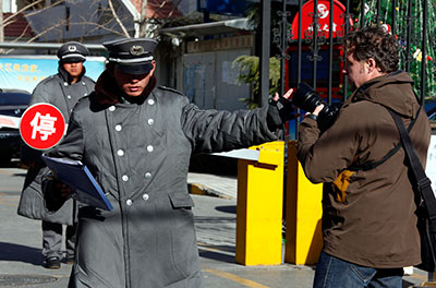A security guard confronts a photographer at the entrance of the compound where Liu Xia lives in Beijing December 10, 2010, after her husband was awarded the Nobel Peace Prize. (Reuters/David Gray)