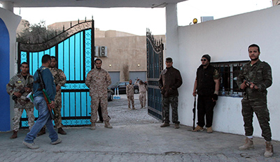 Guards stand outside Alassema TV station in Tripoli. (AFP/Mahmud Turkia)