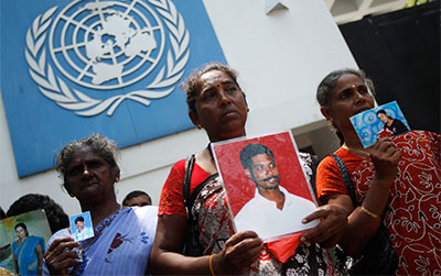 Sri Lankan Tamils hold photos of family members who disappeared in the war between Sri Lankan government troops and Tamil Tiger rebels as they wait to hand over a petition at the U.N. office in Colombo on March 13. (Reuters/Dinuka Liyanawatte)