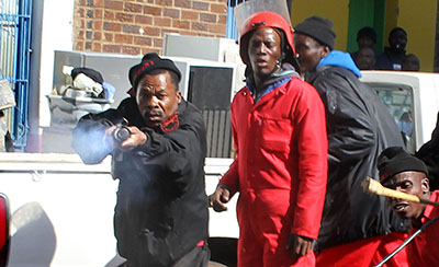 A security officer fires rubber bullets at Star photographer Motshwari Mofokeng. (The Star)