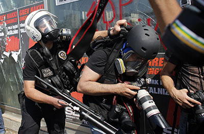 A police officer clashes with a photographer in Taksim Square. (Reuters/Murad Sezer)