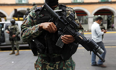 Several journalists, including Miguel Angel López, have fled Veracruz state fearing reprisal from cartels, gangs, or the government. Here, a soldier is seen standing guard in downtown Veracruz. (Reuters/Edgard Garrido)