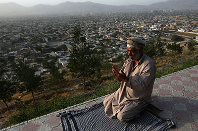 A man offers evening prayers on a hilltop overlooking Kabul on Wednesday. As the devout mark the holy month of Ramadan, Afghanistan's warlords and powerbrokers must decide on a successor to President Hamid Karzai. (Reuters/Omar Sobhani)