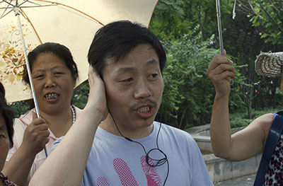 Du Bin speaks on his phone after being released conditionally from jail. (AP/Hu Jia)
