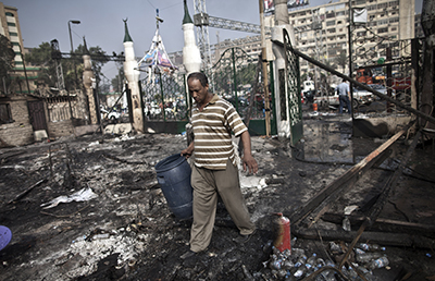 A Egyptian citizen walks through the debris at Rabaa Al-Adawiya square. (AFP/Mahmoud Khaled)