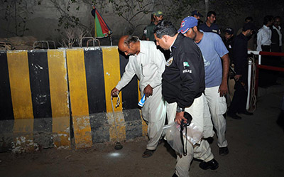 Security officials examine the scene of Monday's attack on Express Media Group in Karachi. (AFP)