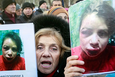 A protester holds pictures of Tetyana Chornovol, who was beaten and left in a ditch hours after publishing an article on the assets of a top government official. (Reuters/Gleb Garanich)