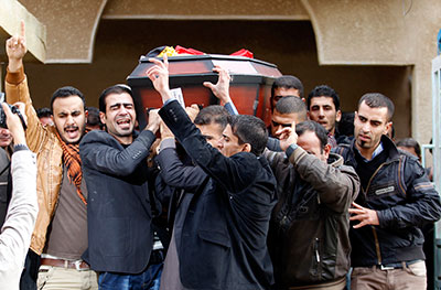 Mourners carry the coffin of Yasser Faisal al-Jumaili, who was killed on assignment in Syria, at his funeral in Falluja, Iraq, on December 8. (Reuters/Thaier Al-Sudani)