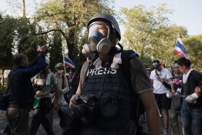 A photographer wears a gas mask to cover the anti-government protest in Bangkok. (AFP/Nicolas Asfouri)