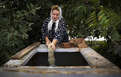 A woman gets her weekly water ration in Sochi. Wells have gone dry since construction began for the Sochi Olympics. (Reuters/Thomas Peter)