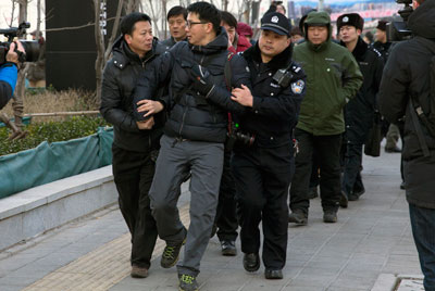 Chinese policemen manhandle a foreign photographer outside the trial of Xu Zhiyong, founder of the New Citizens movement, in Beijing on January 26. (AP/Andy Wong)