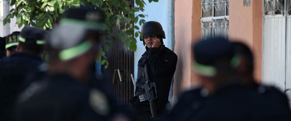 Agentes de la policía hacen guardia cerca de la escena de un crimen el 16 de enero de 2011, en Neza, en las afueras de la ciudad de México. (Reuters / Jorge Dan )