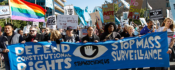 Демонстранты маршируют недалеко от здания конгресса США в Вашингтоне на акции протеста 26 октября 2013 требуя от законодателей провести расследования программ массовой слежки, проводимой Агентством национальной безопасности. (AP/Jose Luis Magana)