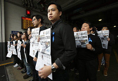 Journalists from Ming Pao hold up front pages of the paper to protest an attack on their former chief editor, Kevin Lau Chun-to. (Reuters/Bobby Yip)