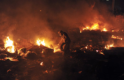 A protester is seen near a barricade of flames between police and demonstrators in Kiev. (AFP/Louisa Gouliamaki)
