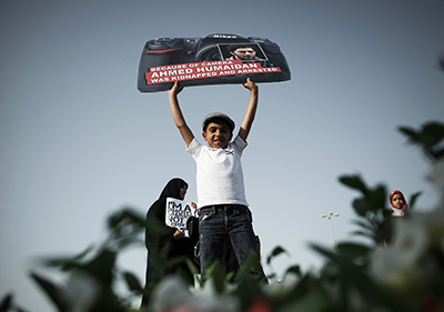 A Bahraini boy holds a sign protesting the December 2012 arrest of freelance photographer Ahmed Humaidan. (AFP/Mohammed al-Shaikh)