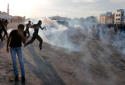 Anti-government protesters take cover from teargas fired by riot police in the village of Daih on March 3. (Reuters/Hamad I Mohammed)