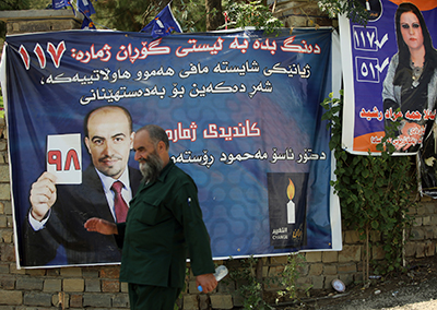 A man walks by a campaign poster for the Gorran party in September 2013. (AFP/Ahmad al-Rubaye)