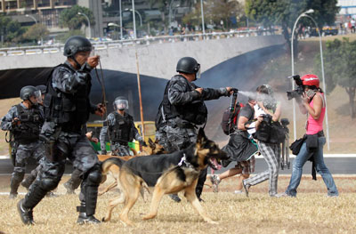 Um policial aponta spray de pimenta para fotógrafos durante um protesto em setembro de 2013. (Reuters/Ueslei Marcelino)
