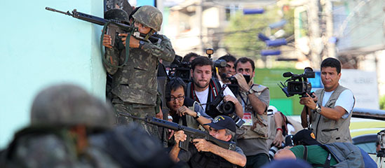 A polícia, soldados e jornalistas tomam posição durante operação em uma favela na capital em novembro de 2010. (Reuters/Sergio Moraes)