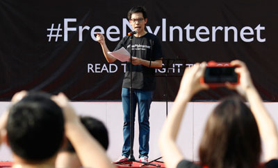 Blogger Roy Ngerng, shown at a June 2013 protest against licensing regulations on news websites, has been fired from his job in health-care since being accused of defamation by the prime minister. (Reuters/Edgar Su)