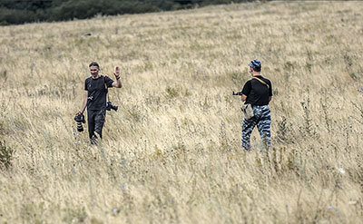 An armed separatist orders a journalist to leave the area near the crash site of the Malaysia Airlines plane in Donetsk region. (AFP/Bulent Kilic)