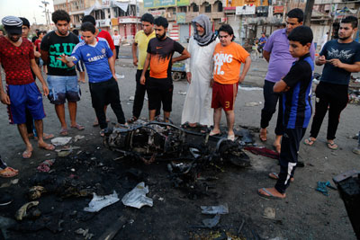 People gather at the site of a bomb attack at a market in Baghdad's Sadr City on Wednesday. (Reuters/Wissm al-Okili)
