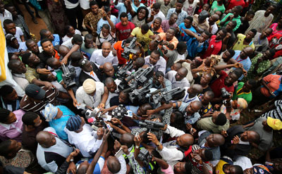 Journalists surround a politician at the start of the Osun state governorship election in southwest Nigeria on August 9, 2014. (Reuters/Akintunde Akinleye)