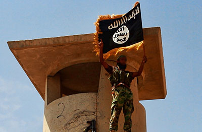 An Islamic State militant stands with the Islamist flag in Iraq. (AFP/Welayat Salahuddin)