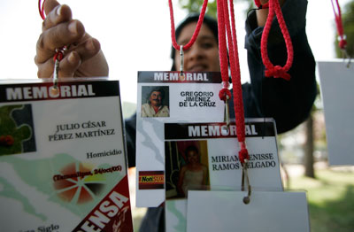 A woman hangs accreditations of journalists killed in recent years while covering the news in Mexico, at a protest in Guadalajara on February 23, 2014. (Reuters/Alejandro Acosta)