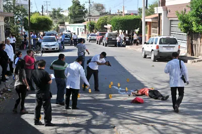 In this May 12, 2014 photo, forensic workers examine the scene where an activist for missing persons was gunned down by unknown assailants in Culiacan, Mexico. (AP/El Debate, Dulce Mercado)